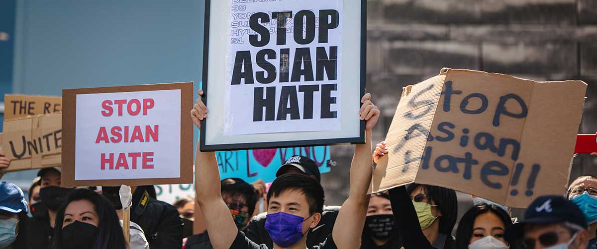 Protesters hold placards to combat Anti-Asian racism