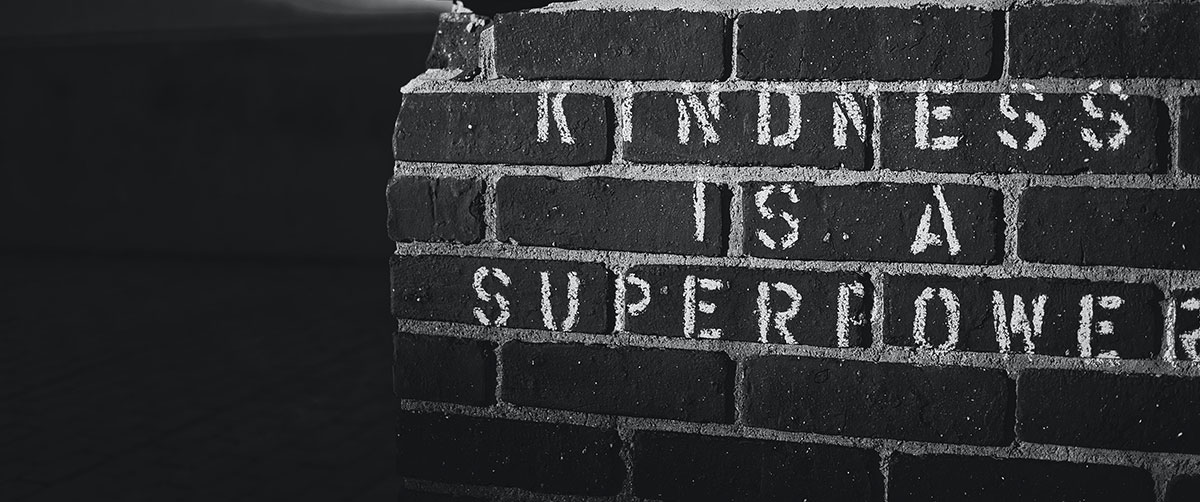 "Kindness is a superpower" written on a wall using chalk