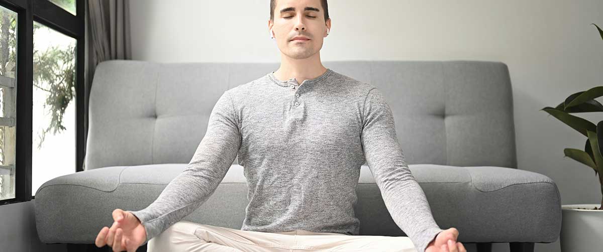 A man meditating in his home