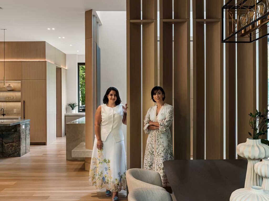 Bahar Zaeem and Shima Radfar standing in a room with tall fluted dividers