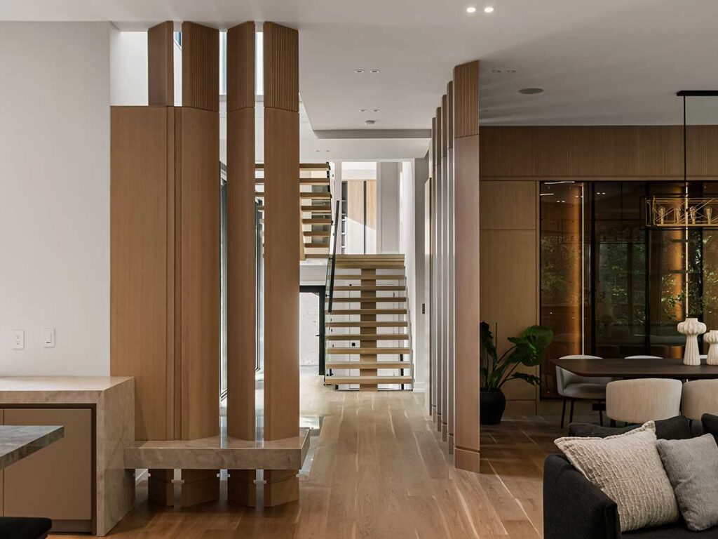 Interior of hallway with tall fluted room dividers and a staircase at the end.